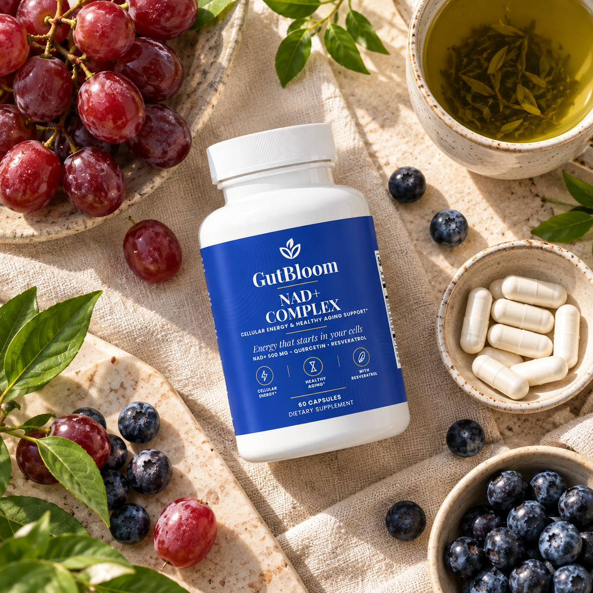 GutBloom NAD+ Complex flat lay with red grapes, blueberries and green tea